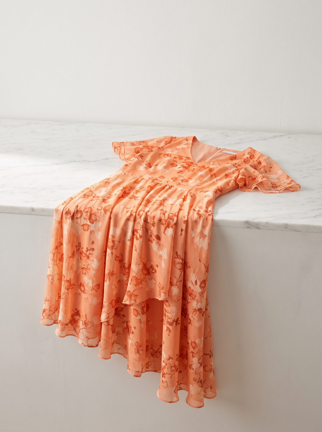 Aurelia dress folded over a white counter